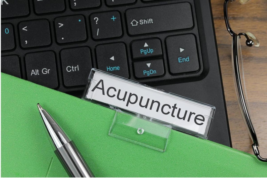 Kontorsmaterial och skylt med texten 'Acupuncture'.